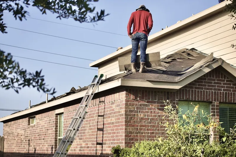 Professional roofer working on a residential roof in Pond Meadow